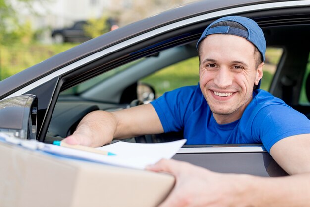 Free photo happy delivery guy holding box