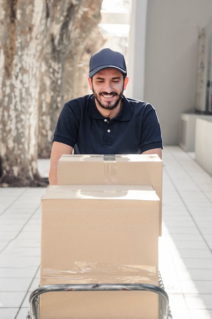 Free photo happy delivery man with cardboard boxes