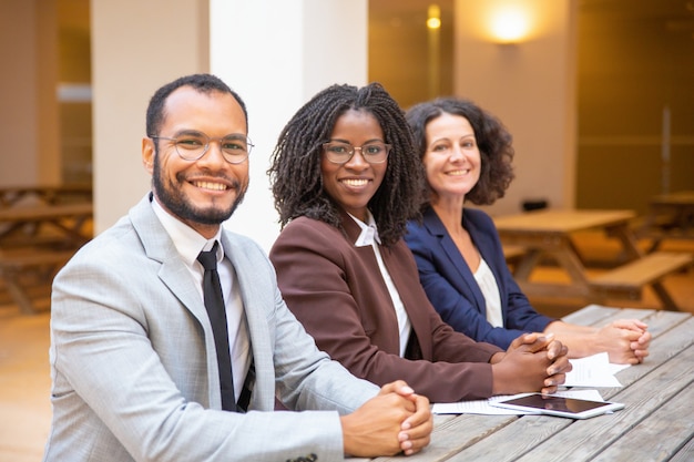 Happy diverse business team posing in street cafe