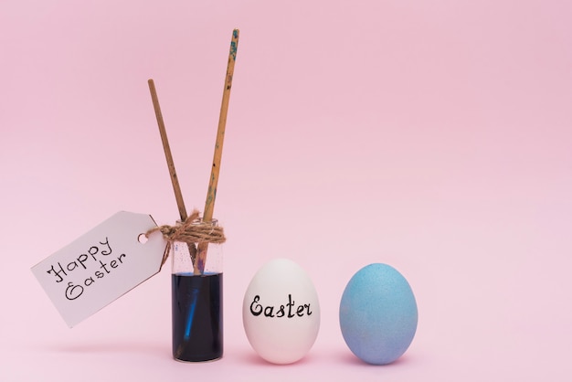 Happy Easter inscription with eggs and paint brush