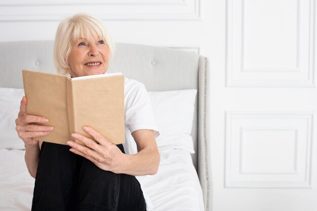 Happy elder woman holding a book