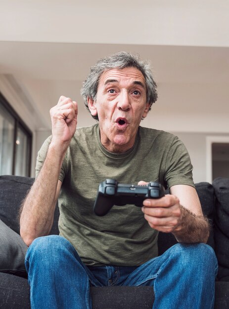 Happy elderly man playing video game