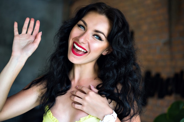 Happy emotional portrait of happy brunette woman smiling and laughing, blue eyes and bright make up.