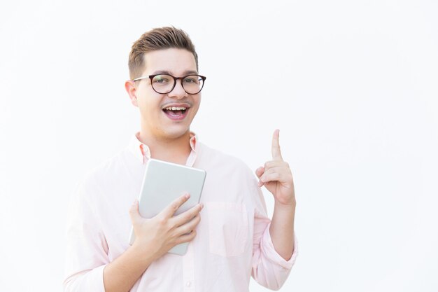 Happy excited guy in eyeglasses holding tablet