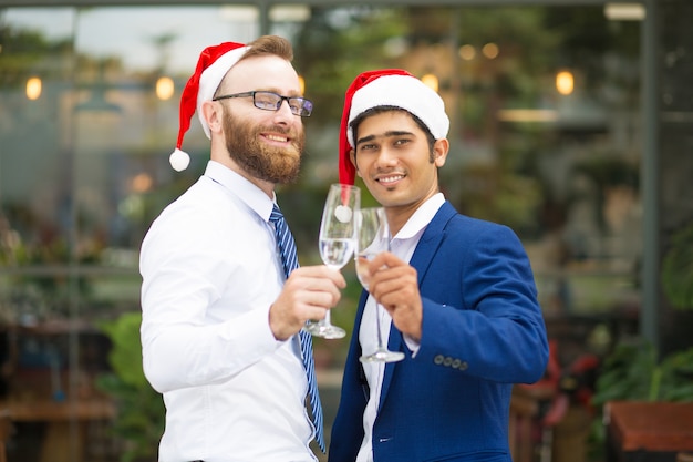 Free photo happy excited multi-ethnic men clinking champagne flutes