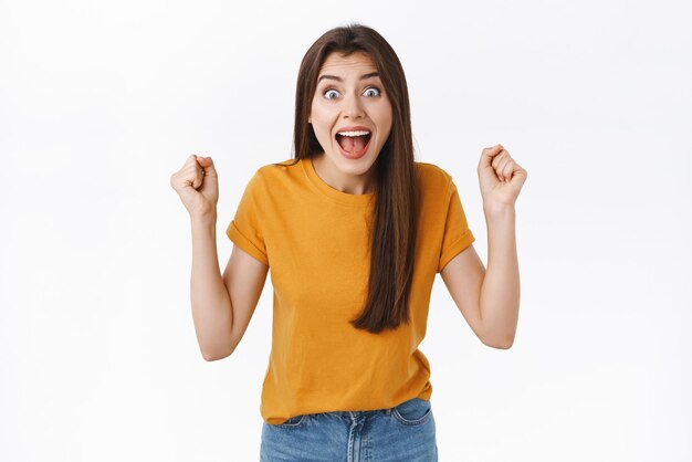 Happy excited and relieved young woman heart amazing news fist pump raise clenched hands in joy and amazement stare camera surprised scream from delight triumphing celebrating victory winning