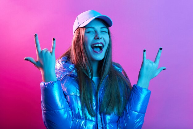 Happy excited woman showing rock gesture with fingers