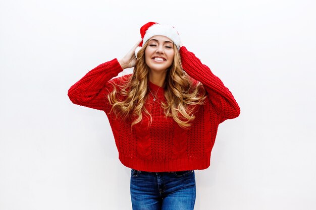 Happy face. Ecstatic woman in red masquerade new year hat and sweater