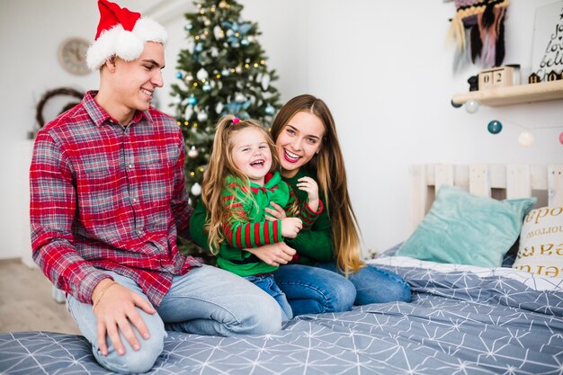 Happy family on bed at christmas