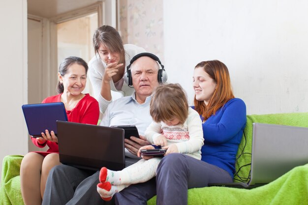 Happy family enjoys   with few various laptops