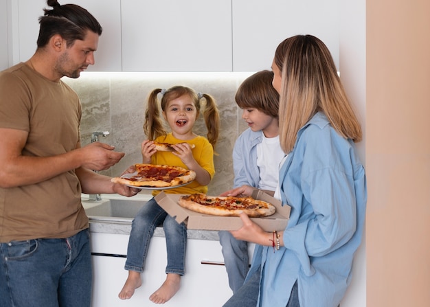 Free photo happy family having pizza in their new home