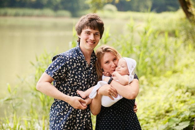 Free photo happy family. mom and dad have fun with their little son resting in a green summer park