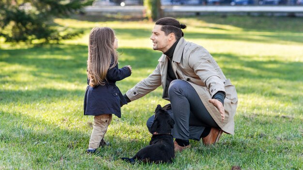 Free photo happy family in a park father wants to hug his daughter