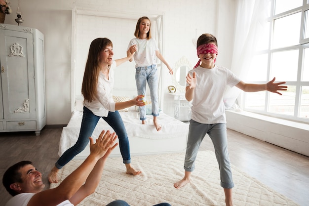 Happy family playing blind man's buff at home