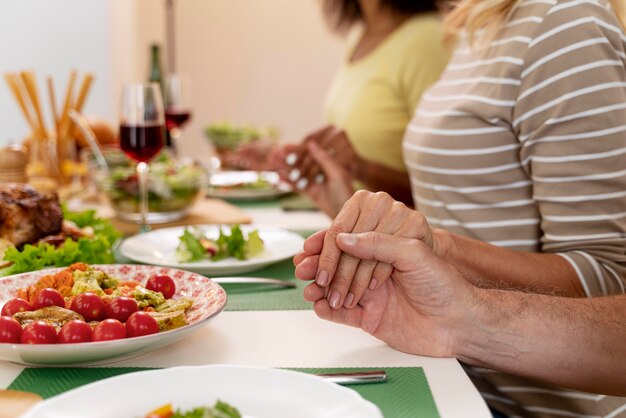 Happy family praying before having dinner together