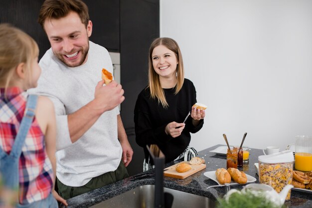 Happy family preparing open sandwiches 