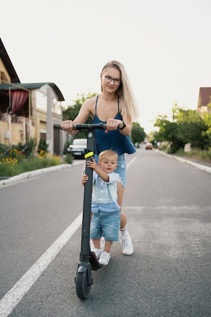 Happy family riding scooter in the neighborhood on the road.