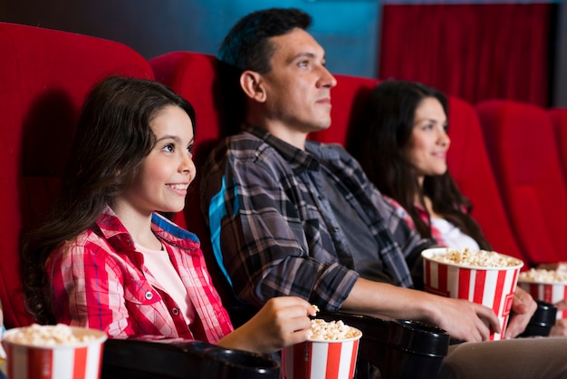 Happy family sitting in cinema