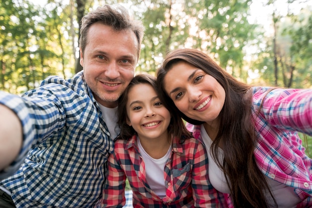 Happy family taking selfie in park