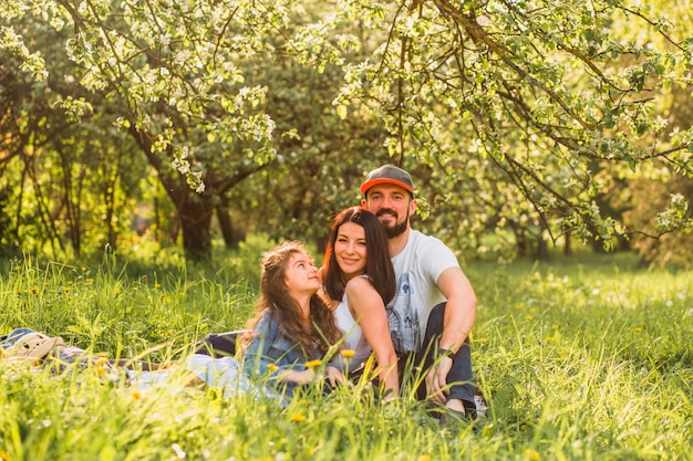 Happy family with daughter sitting in park