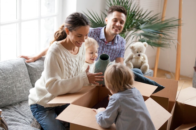 Free photo happy family with kids unpacking boxes moving into new home