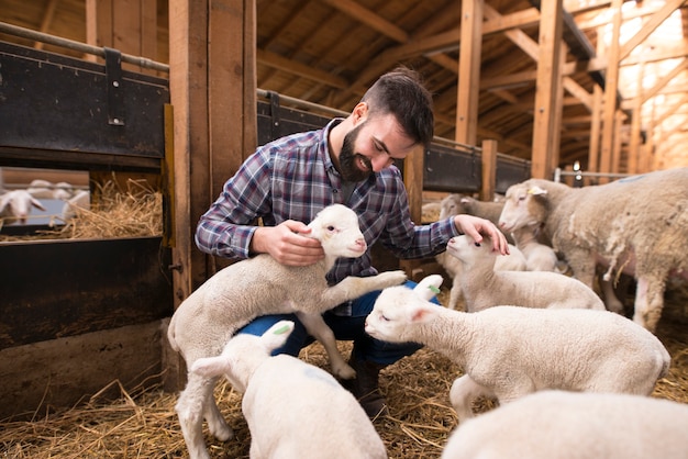 Free photo happy farmer playing with animals at farm