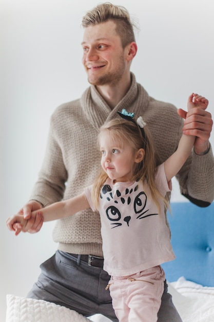 Free photo happy father holding his daughter's arms