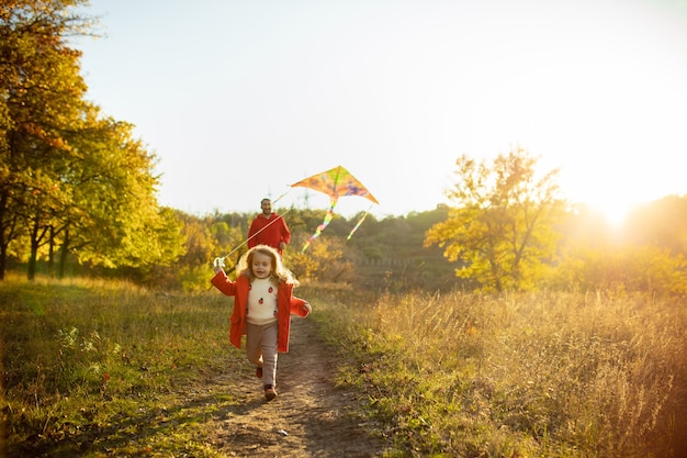 Free Photo happy father and little cute daughter walking down the forest path in autumn sunny day