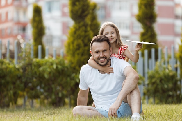 happy father playing with daughter planes outdoor