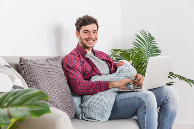 Free photo happy father with baby using laptop