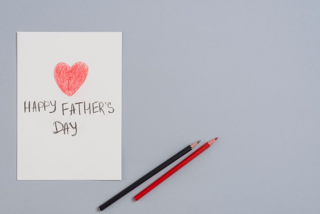 Free photo happy fathers day inscription on paper sheet with pencils