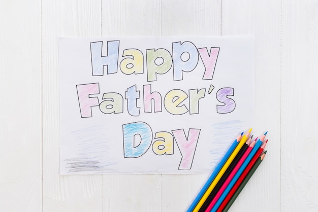 Happy Fathers Day inscription with pencils on table