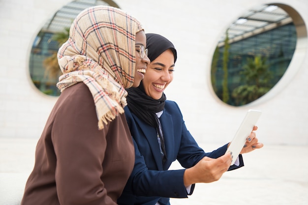 Free Photo happy female colleagues using tablet for video call