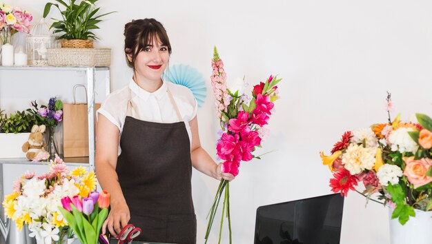 Happy female florist with bunch of flowers