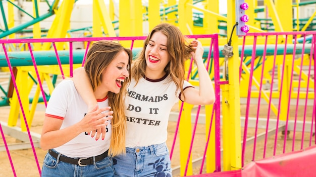 Free Photo happy female friends having fun at amusement park