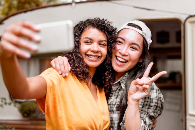 Happy female friends making the peace sign