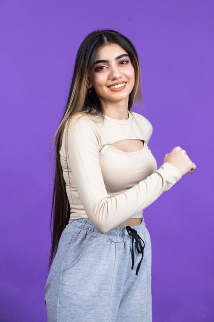 Happy female stands on purple background High quality photo