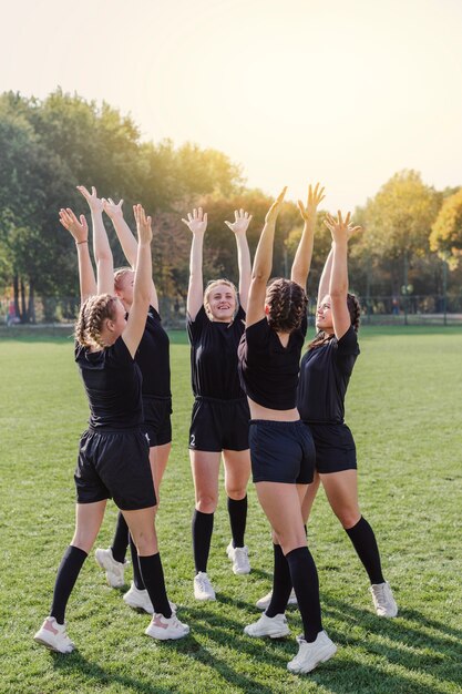 Happy female team raising hands