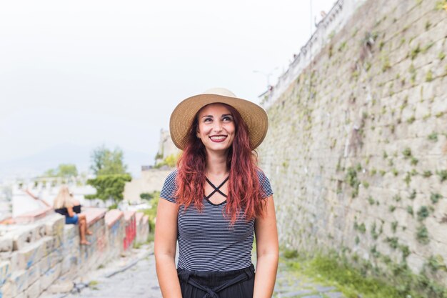 Happy female tourist next to wall