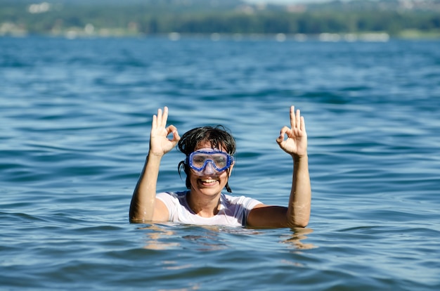 Free photo happy female with short hair in the middle of the calm water of a lake