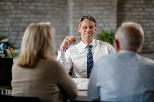 Free Photo happy financial advisor communicating with senior couple while having meeting with them in the office