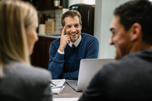 Free Photo happy financial advisor talking to a couple while having a meeting at their home