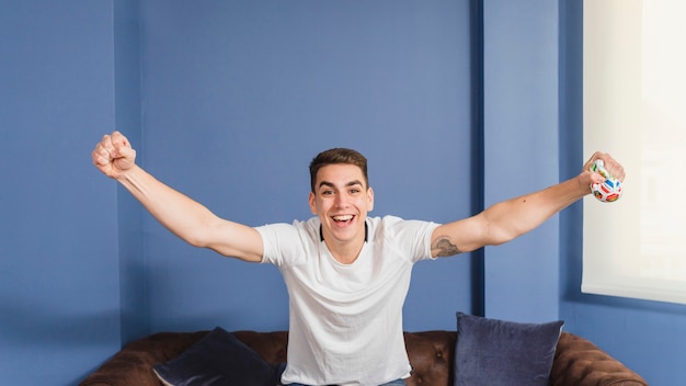 Free Photo happy football fan on couch