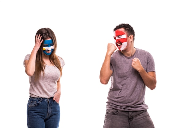 Happy Football fan of Croatia celebrate win over upset football fan of Argentina with painted face