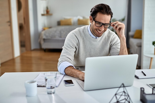 Happy freelance worker using computer while working at home