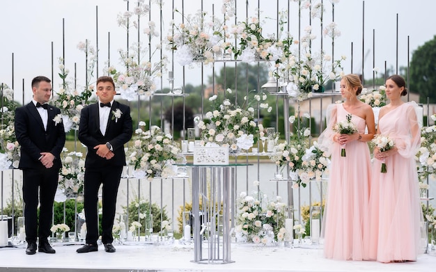 Free photo happy frieds of brides near wedding decorative arch