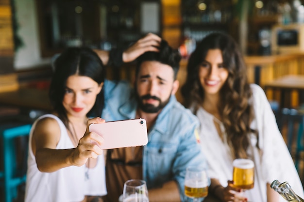 Happy friends in bar posing for selfie