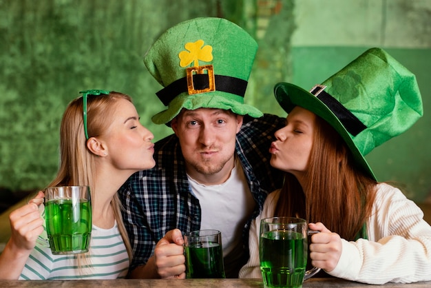 Free photo happy friends celebrating together st. patrick's day at the bar with drinks