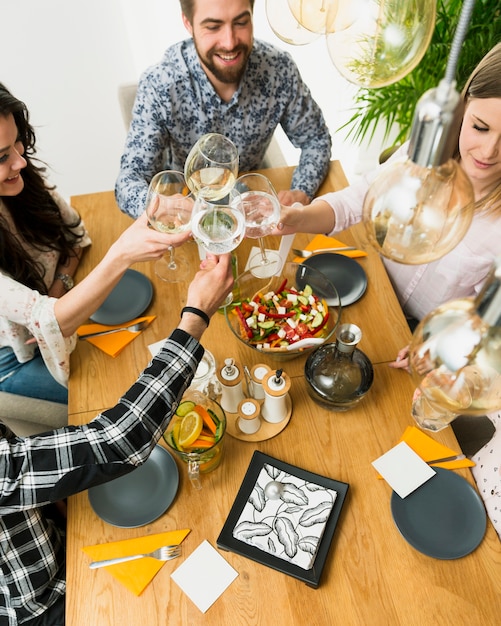 Free Photo happy friends clinking wine glasses