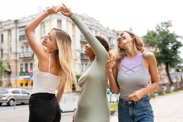 Free photo happy friends dancing in the streets